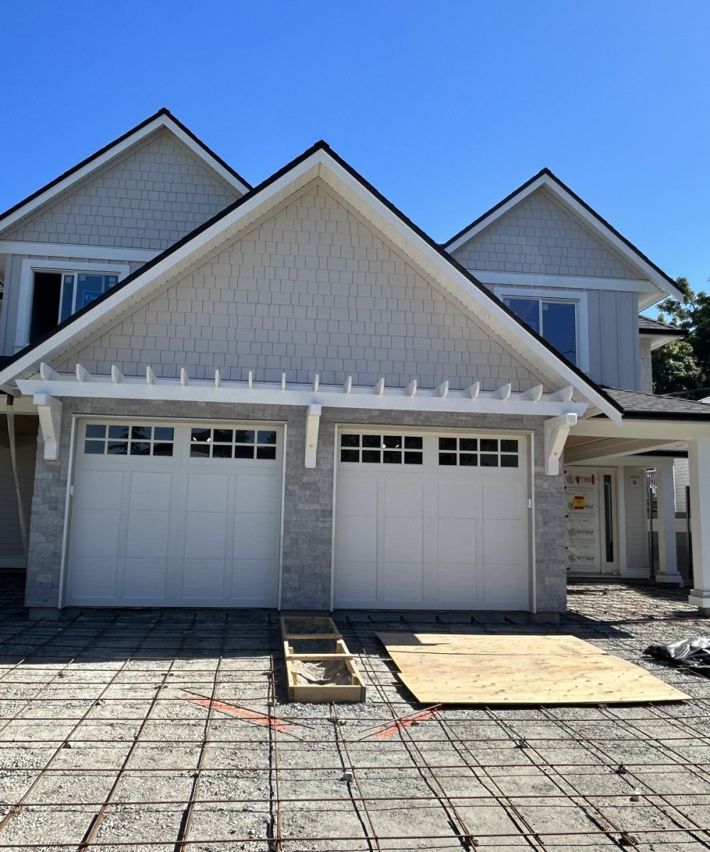 Clopay Coachman Model CG12 white garage doors installed on a new build home in Ladner BC