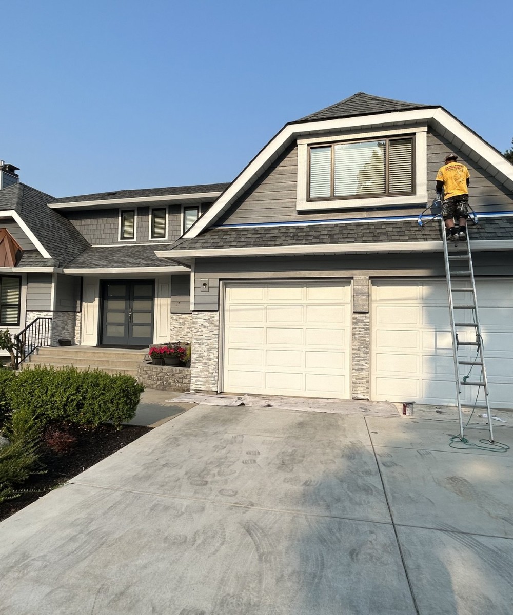 Hormann 3400 black long-panel garage door with glass top sections in North Vancouver