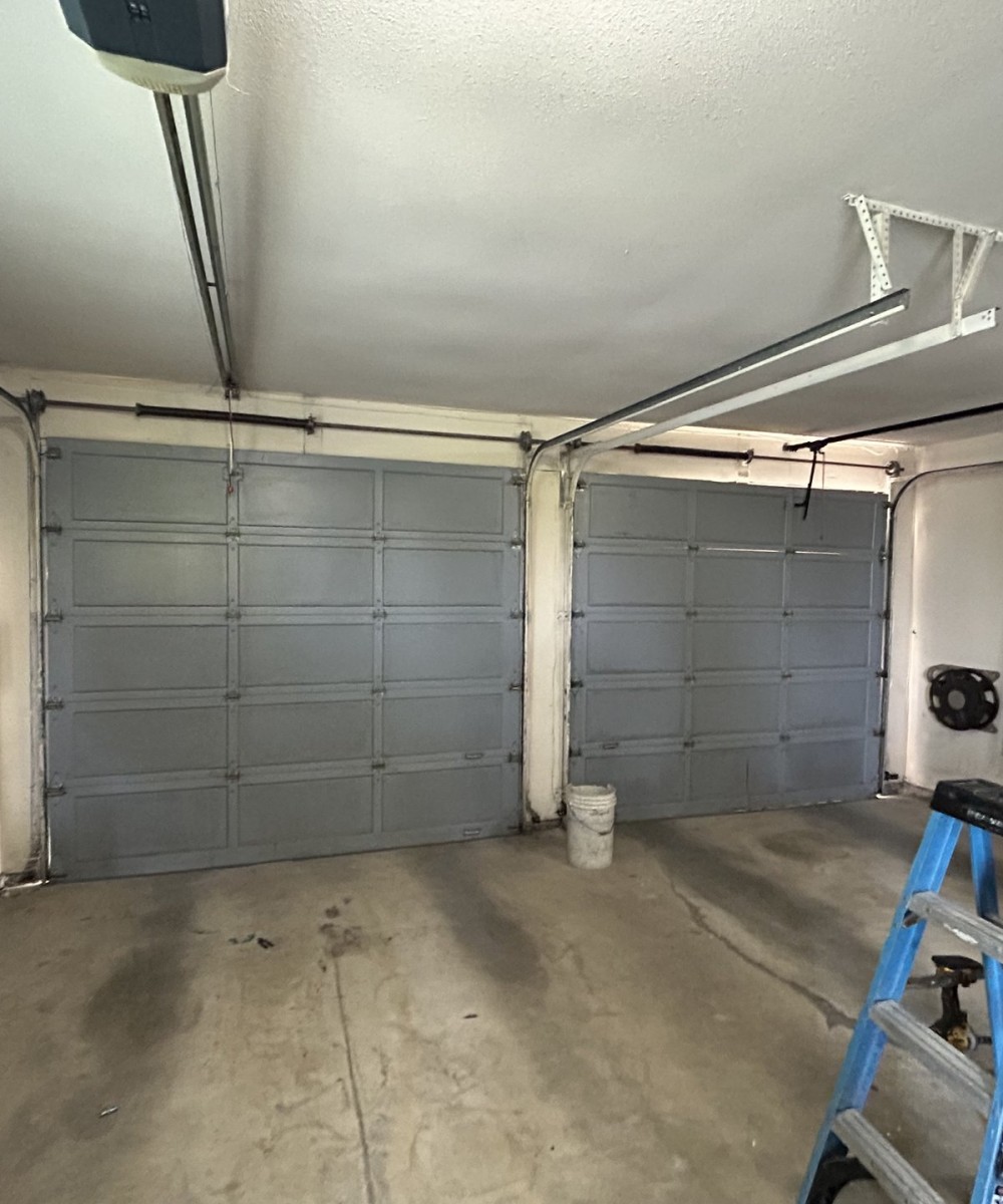 Hormann 3400 black long-panel garage door with glass top sections in North Vancouver