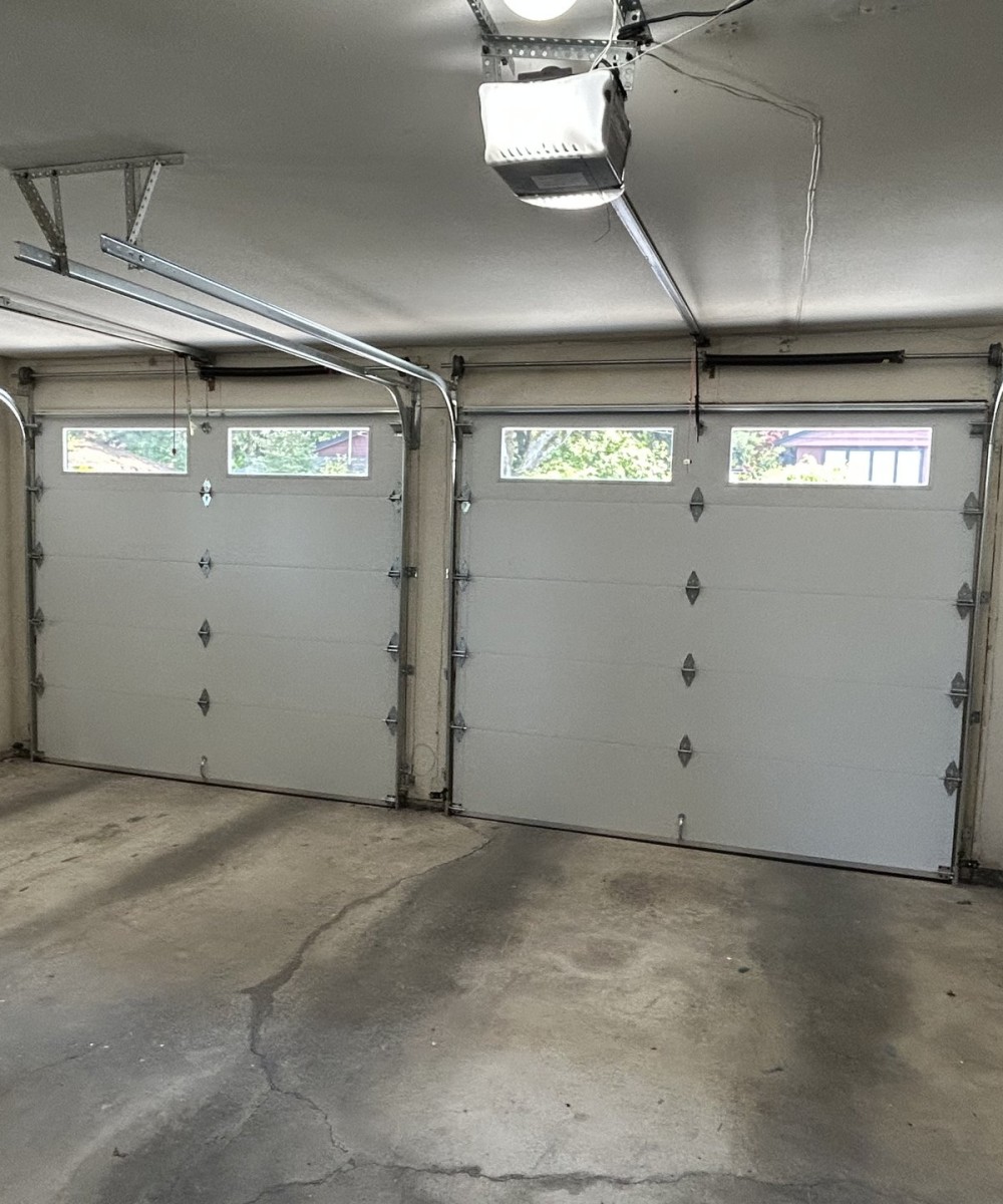 Hormann 3400 black long-panel garage door with glass top sections in North Vancouver