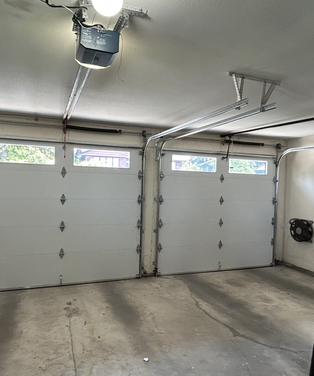 Hormann 3400 black long-panel garage door with glass top sections in North Vancouver